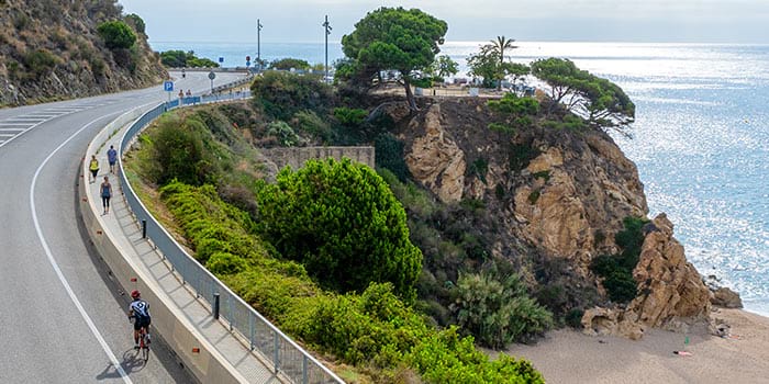 Ciclista per la carretera de la costa de Calella Ciclista a su paso por Calella